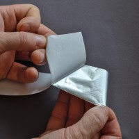 Foto das zeigt, wie man Isolierband von der Klebefläche abzieht.